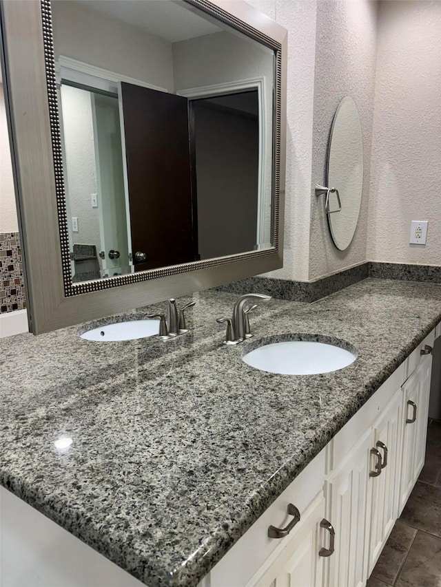 bathroom featuring vanity and a textured wall