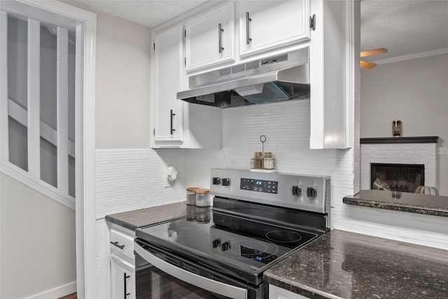 703 Trinidad Dr, Grand Prairie, TX 75052 - kitchen with electric stove, under cabinet range hood, a textured ceiling, white cabinets, and backsplash