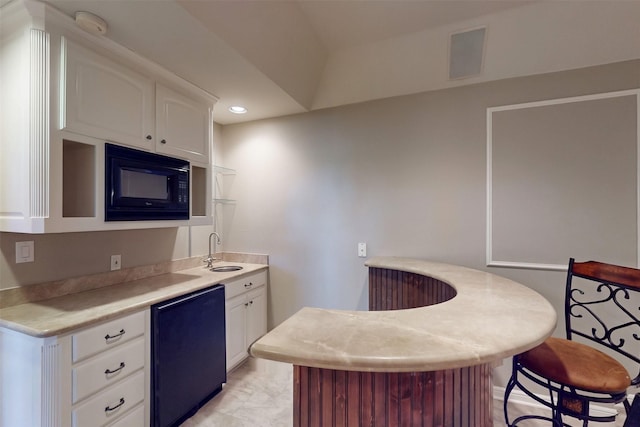 1908 Kings Pass, Heath, TX 75032 - kitchen featuring fridge, visible vents, a sink, black microwave, and white cabinets
