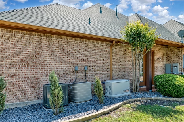 1908 Kings Pass, Heath, TX 75032 - view of property exterior featuring central air condition unit, roof with shingles, and brick siding