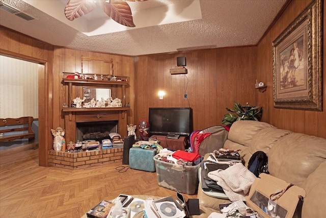 210 E Warren St, Wolfe City, TX 75496 - living area with a fireplace, a textured ceiling, visible vents, and wood walls