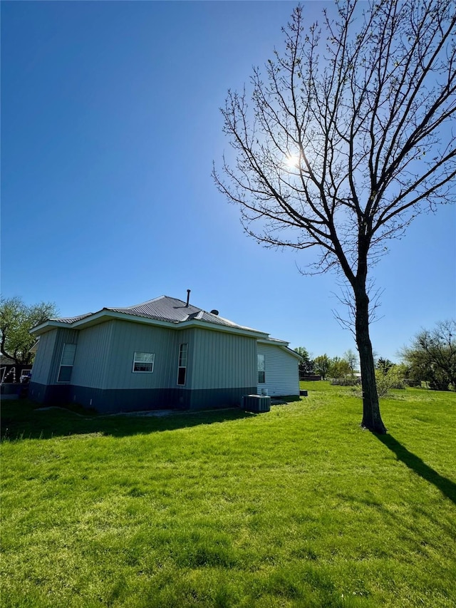 210 E Warren St, Wolfe City, TX 75496 - exterior space featuring central AC unit and a lawn