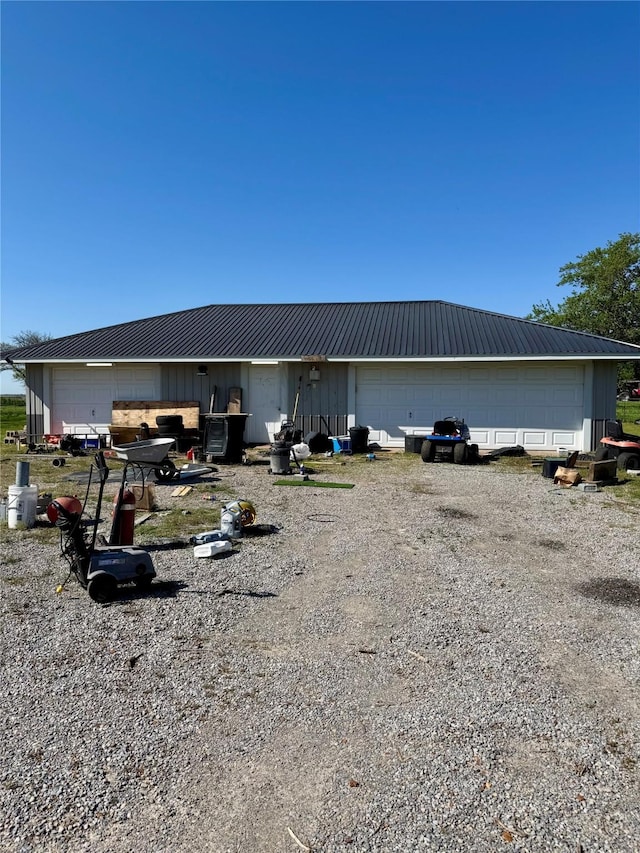 210 E Warren St, Wolfe City, TX 75496 - back of property with metal roof, board and batten siding, and a detached garage