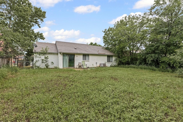 2405 Sweetwood Dr, Fort Worth, TX 76131 - rear view of property featuring brick siding, fence, a lawn, and central AC