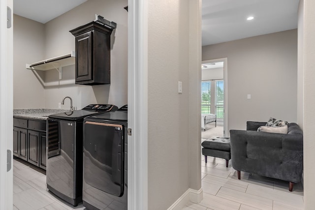laundry area with a sink, cabinet space, separate washer and dryer, baseboards, and recessed lighting