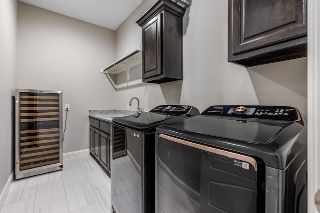 laundry area with beverage cooler, baseboards, wet bar, separate washer and dryer, and cabinet space