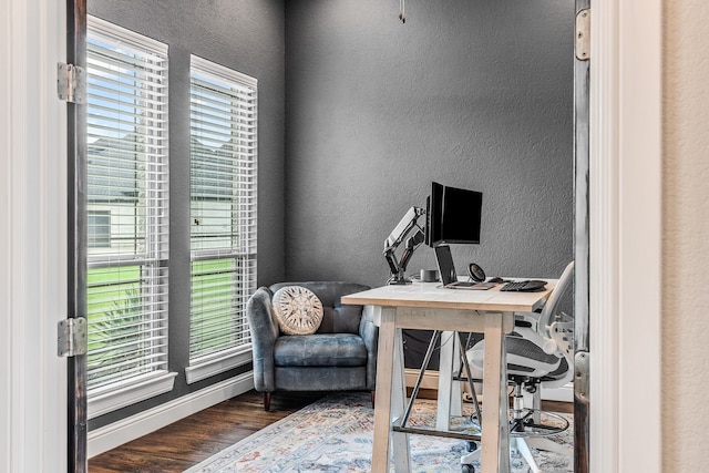 office featuring baseboards, wood finished floors, and a textured wall