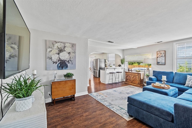 2512 Halloran St, Fort Worth, TX 76107 - living area featuring wood finished floors, a textured ceiling, visible vents, arched walkways, and baseboards