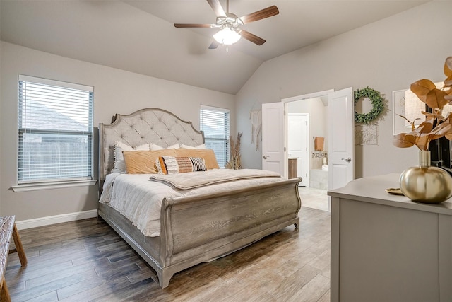 bedroom with vaulted ceiling, ensuite bathroom, baseboards, and wood finished floors