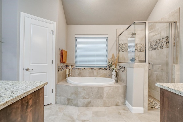 bathroom with vanity, lofted ceiling, a garden tub, and a shower stall