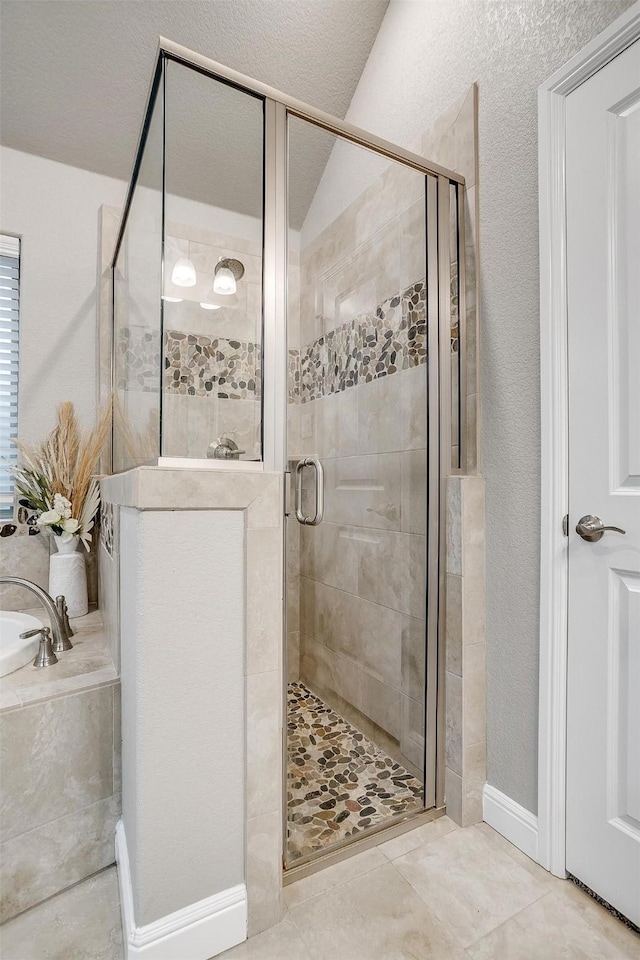 bathroom featuring a garden tub, tile patterned flooring, and a shower stall