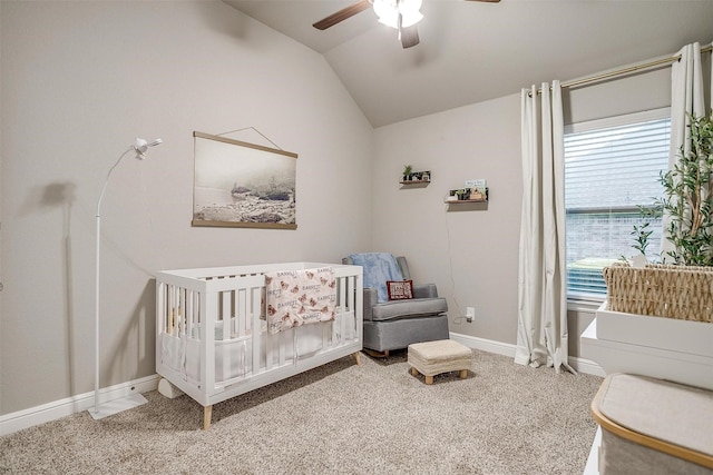 bedroom with a crib, carpet flooring, baseboards, and lofted ceiling