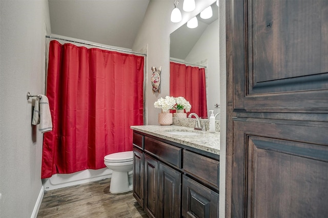 bathroom with toilet, wood finished floors, shower / bath combo with shower curtain, lofted ceiling, and vanity