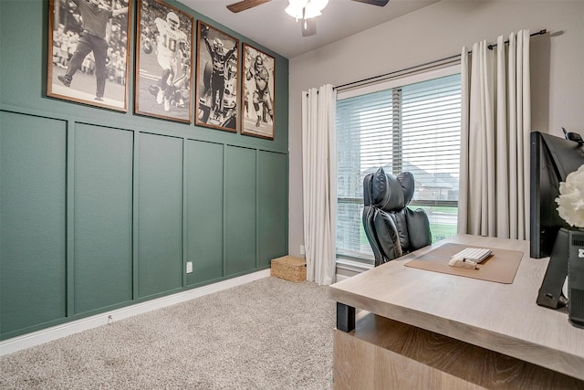 carpeted home office with a decorative wall and a ceiling fan