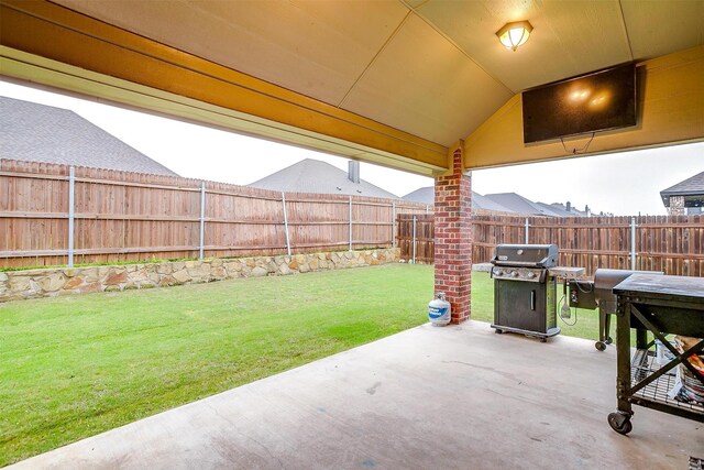 view of patio with area for grilling and a fenced backyard