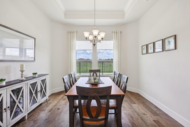 846 Cordoba Ln, Rockwall, TX 75087 - dining room with a raised ceiling, a chandelier, ornamental molding, dark wood-type flooring, and baseboards