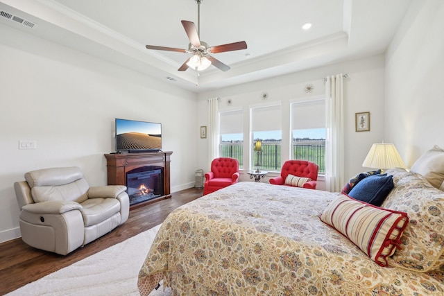 846 Cordoba Ln, Rockwall, TX 75087 - bedroom featuring a raised ceiling, wood finished floors, a glass covered fireplace, baseboards, and recessed lighting