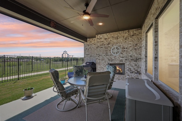 846 Cordoba Ln, Rockwall, TX 75087 - patio terrace at dusk featuring an outdoor brick fireplace, ceiling fan, and outdoor dining area