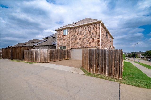5117 Wakefield Dr, Irving, TX 75038 - view of side of home featuring driveway, brick siding, an attached garage, and fence