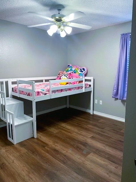 502 Blueberry Hill Ln, Mansfield, TX 76063 - bedroom featuring a textured ceiling, wood finished floors, baseboards, and ceiling fan