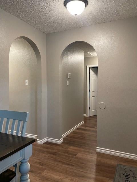 502 Blueberry Hill Ln, Mansfield, TX 76063 - hallway with wood finished floors, a textured ceiling, arched walkways, and baseboards