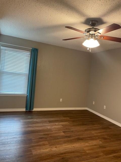 502 Blueberry Hill Ln, Mansfield, TX 76063 - spare room with ceiling fan, dark wood-style flooring, a textured ceiling, and baseboards