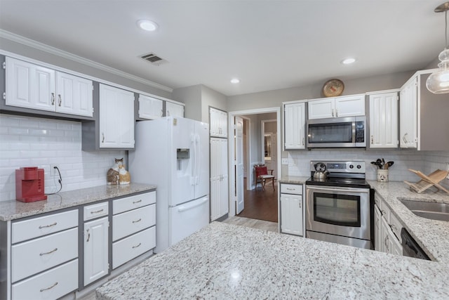 kitchen with ornamental molding, stainless steel appliances, light stone counters, and visible vents