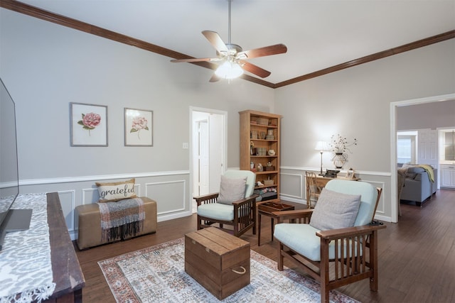 sitting room featuring ornamental molding, a ceiling fan, and wood finished floors