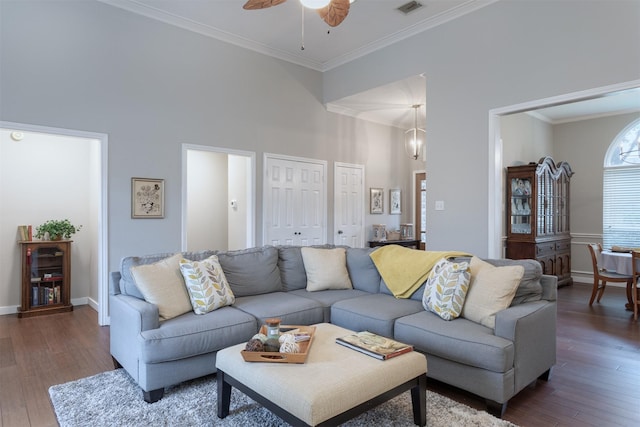 living room featuring baseboards, a ceiling fan, ornamental molding, and hardwood / wood-style flooring