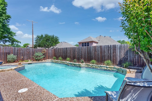 view of swimming pool featuring a pool with connected hot tub and a fenced backyard
