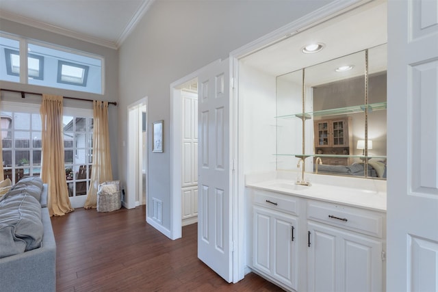 interior space with wood finished floors, vanity, ornamental molding, recessed lighting, and baseboards