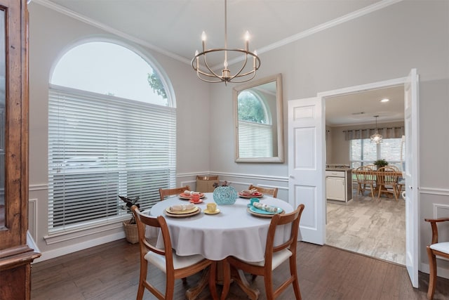 dining space featuring a wealth of natural light, ornamental molding, an inviting chandelier, and dark wood-style floors