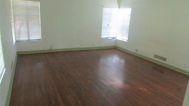 1509 N Gaines St, Ennis, TX 75119 - empty room featuring baseboards, visible vents, and wood finished floors