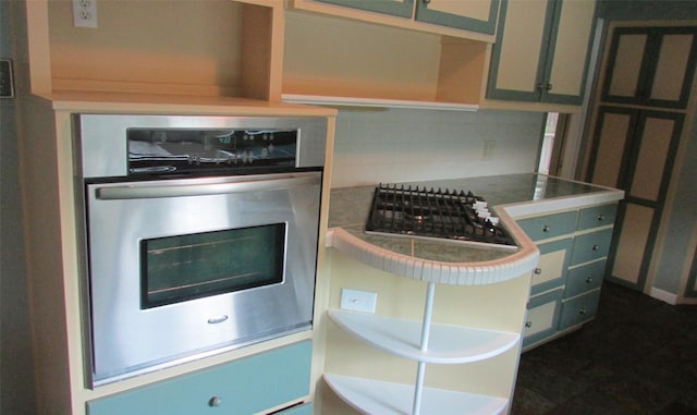 1509 N Gaines St, Ennis, TX 75119 - kitchen view of stainless steel appliances, tasteful backsplash, and open shelves