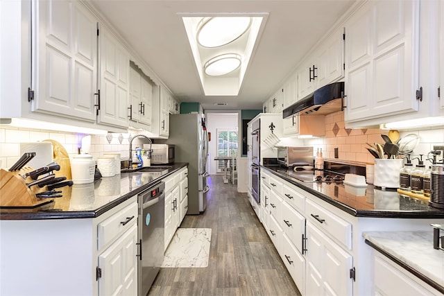 1307 S Westador Dr, Arlington, TX 76015 - kitchen with stainless steel appliances, under cabinet range hood, and white cabinetry