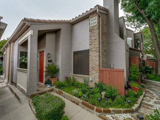 4242 N Capistrano Dr Unit 203, Dallas, TX 75287 - view of front of home with stucco siding and fence