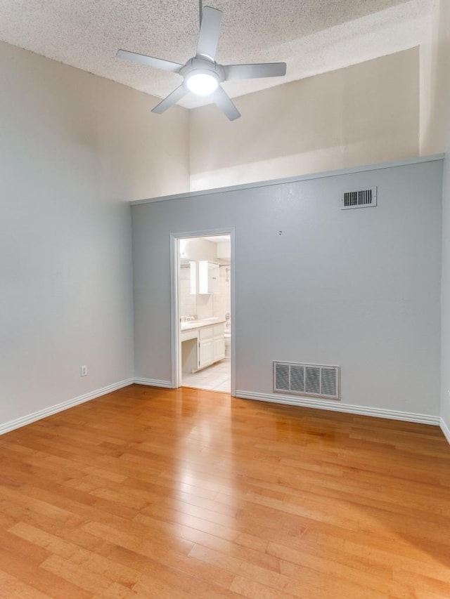 4242 N Capistrano Dr Unit 203, Dallas, TX 75287 - unfurnished room with light wood-style floors, visible vents, a towering ceiling, and ceiling fan