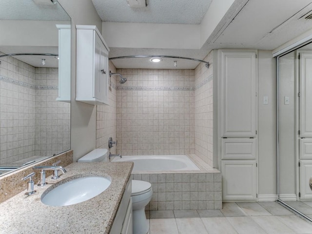 4242 N Capistrano Dr Unit 203, Dallas, TX 75287 - bathroom featuring toilet, tiled shower / bath combo, a textured ceiling, tile patterned flooring, and vanity