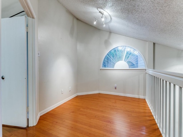 4242 N Capistrano Dr Unit 203, Dallas, TX 75287 - unfurnished room featuring a textured ceiling, baseboards, and light wood-style floors