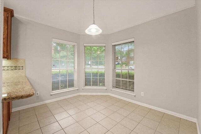 unfurnished dining area with light tile patterned floors, baseboards, and vaulted ceiling
