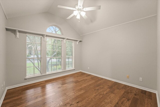 spare room with vaulted ceiling, a ceiling fan, wood finished floors, and baseboards
