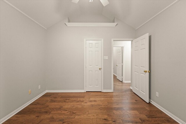 spare room with a ceiling fan, lofted ceiling, wood finished floors, and baseboards