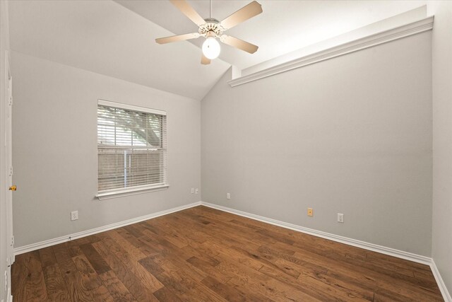 spare room with vaulted ceiling, dark wood finished floors, baseboards, and ceiling fan