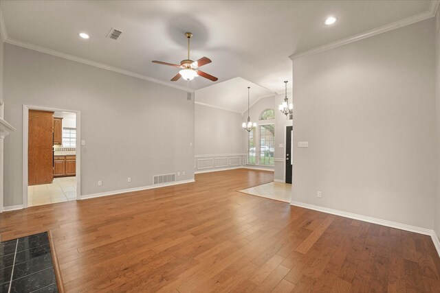 unfurnished living room with a chandelier, ceiling fan, light wood-type flooring, ornamental molding, and vaulted ceiling