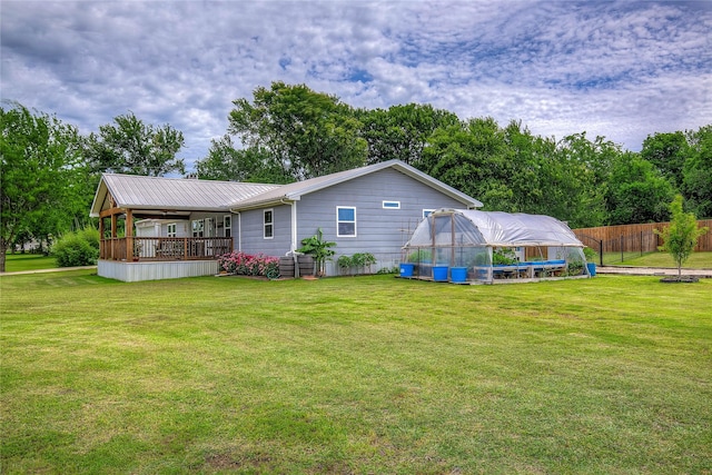 185 Seminole Trl, East Tawakoni, TX 75472 - back of property with a yard, an outbuilding, a greenhouse, fence, and metal roof