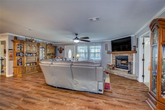 185 Seminole Trl, East Tawakoni, TX 75472 - living room featuring wood finished floors, a fireplace, visible vents, ceiling fan, and ornamental molding