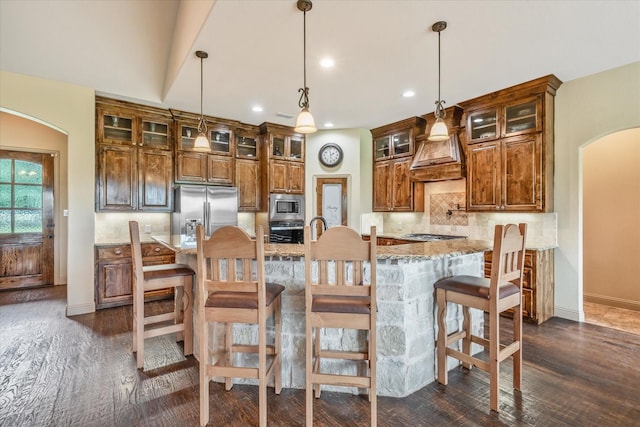 360 Rs County Road 3419, Emory, TX 75440 - kitchen with appliances with stainless steel finishes, arched walkways, custom range hood, backsplash, and dark wood finished floors