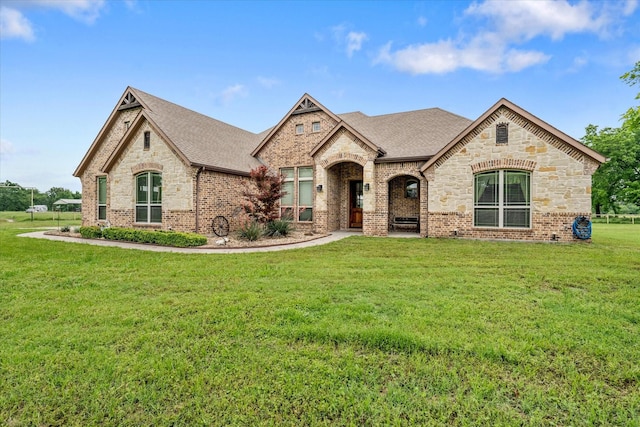 360 Rs County Road 3419, Emory, TX 75440 - french country inspired facade featuring roof with shingles, brick siding, a front lawn, and stone siding