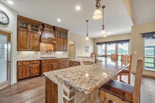 360 Rs County Road 3419, Emory, TX 75440 - kitchen with a sink, custom exhaust hood, dark wood-style flooring, arched walkways, and a kitchen bar