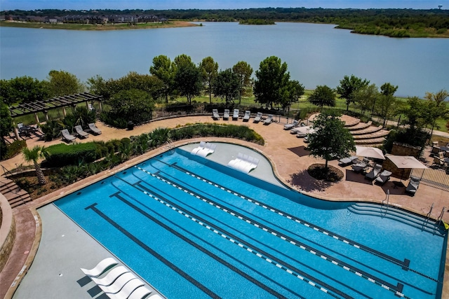 community pool with a water view and fence